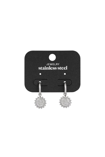 Silver sun charm hoop earrings displayed on a black jewelry card with 'stainless steel' written above