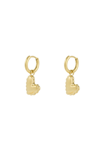 Close-up of gold heart charm drop earrings with scalloped puffed heart design against white background