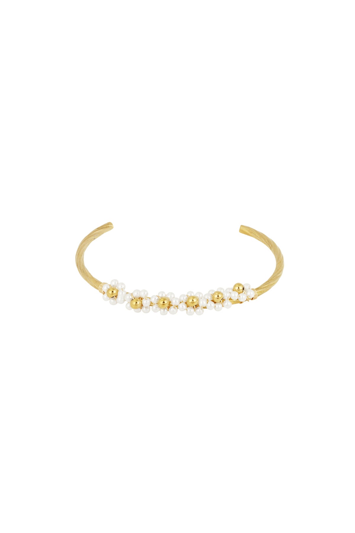 Close-up of a gold-tone open cuff bracelet adorned with clusters of small imitation pearls arranged like flowers.