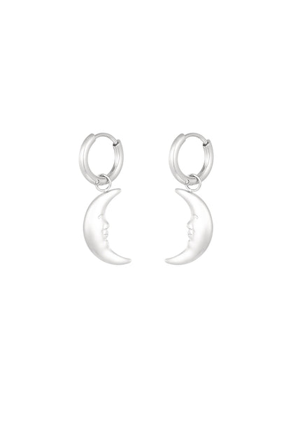 Pair of silver crescent moon face dangling hoop earrings on white background