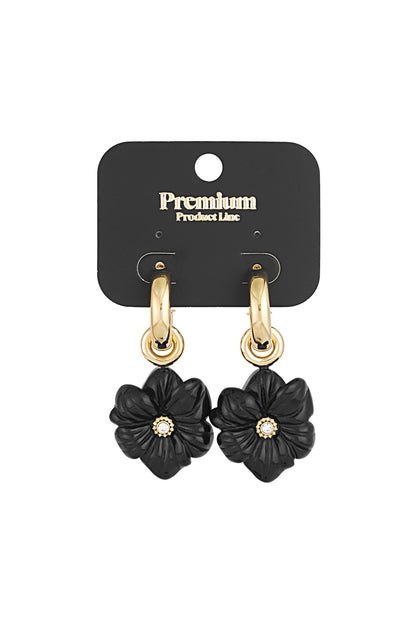 Gold-tone hoop earrings with black flower charm displayed on a black Premium Product Line card