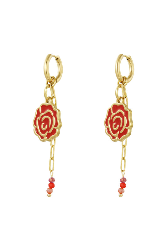 Gold-tone drop earrings with red enamel rose pendants and small dangling red glass beads on a white background