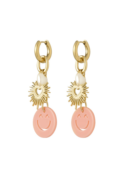 Pair of gold-tone drop earrings with peach smiley face acrylic charms, sunburst heart pendants, and white pearl heart details