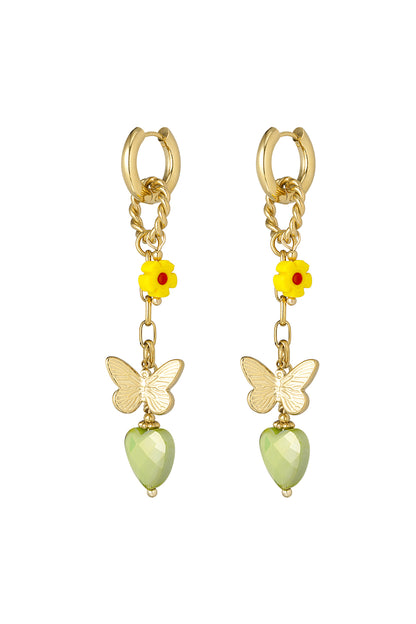 Gold drop earrings with yellow flower, butterfly charm, and faceted light green heart pendant on white background