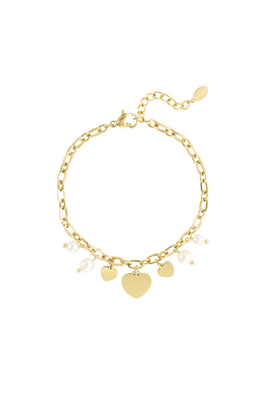 Gold-tone charm bracelet with small and large heart pendants and pearl beads on a delicate chain.