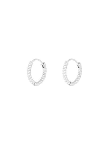 Pair of silver twisted rope hoop earrings on white background