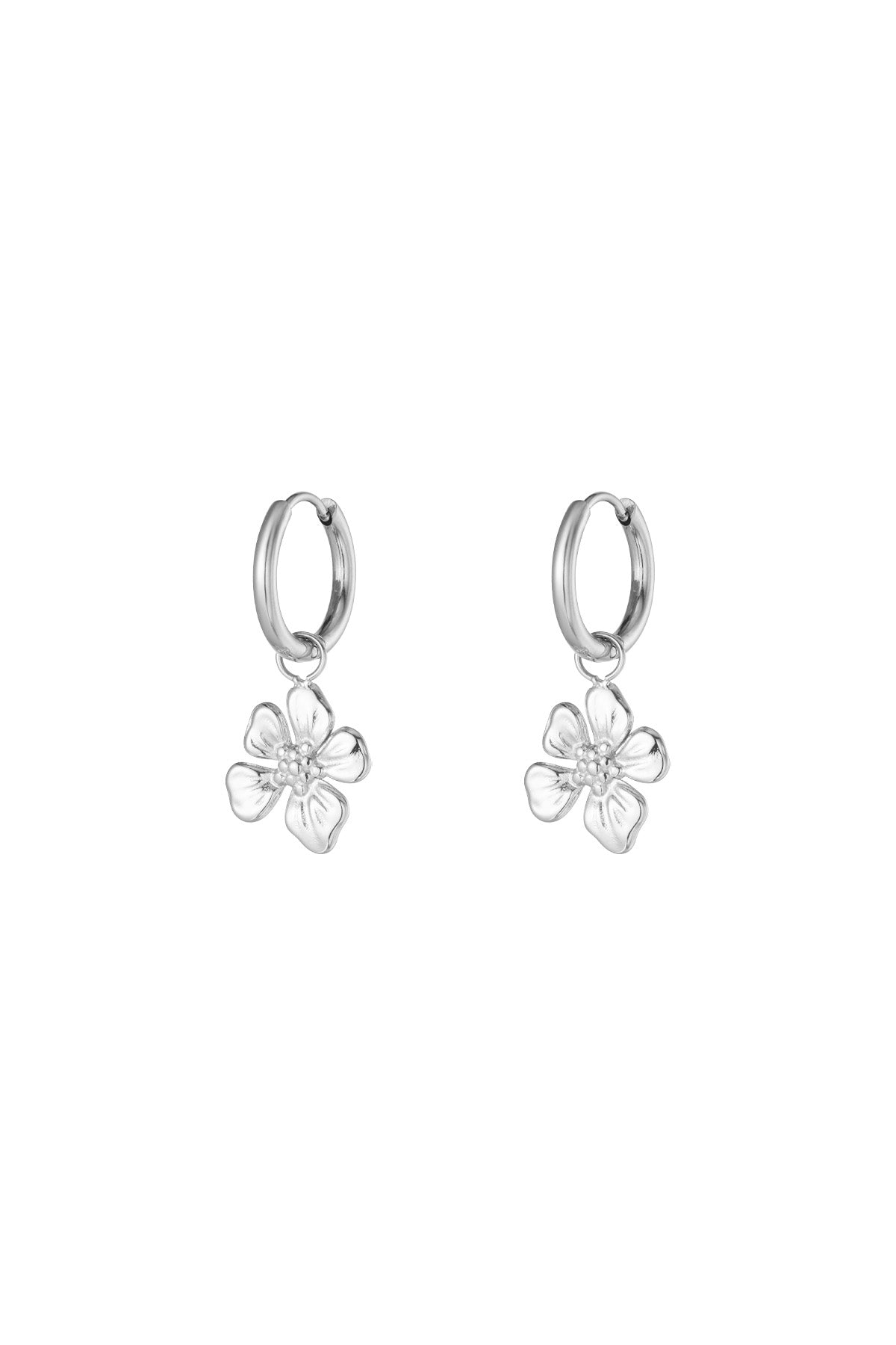 Pair of silver hoop earrings each featuring a dangling detailed flower charm on a white background