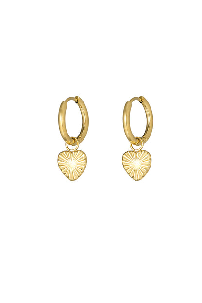 Gold hoop earrings featuring embossed sunburst heart charms on a white background