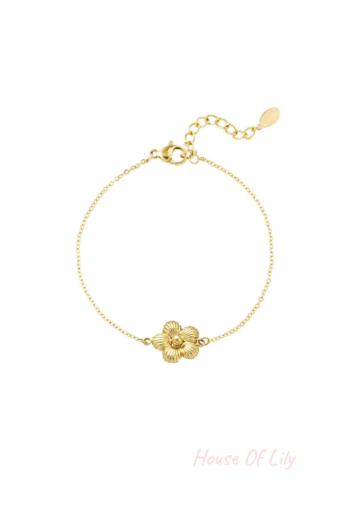 Gold bracelet featuring a finely detailed daisy charm on a delicate chain with adjustable clasp on white background