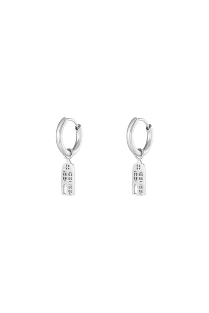Pair of silver drop hoop earrings with narrow building-shaped dangling charms on a white background