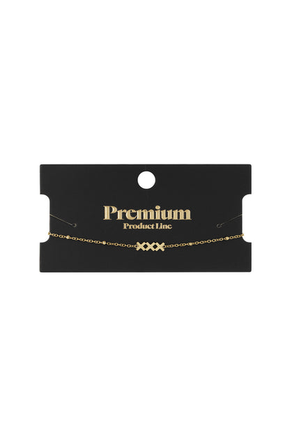 Gold charm bracelet displayed on a black card labelled 'Premium Product Line'