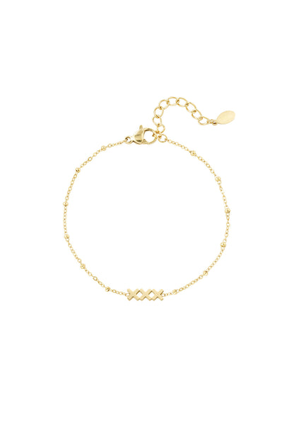 Close-up of a delicate gold bracelet with 'XXX' charm and adjustable chain on a white background