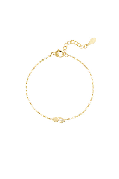 Close-up of a delicate gold tulip charm bracelet with chain extender and lobster clasp on white background