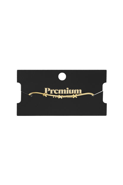 Triple X charm bracelet displayed on black boutique packaging card