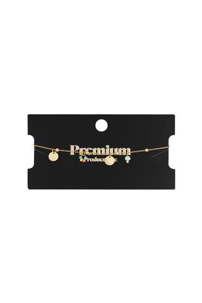 Gold coin bracelet delicately displayed on a black card with 'Premium' written in gold text