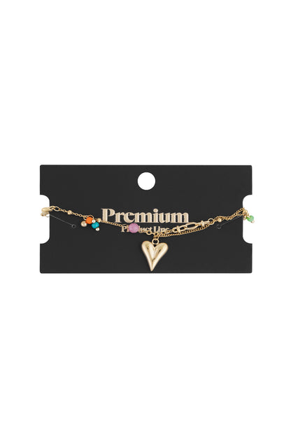 Golden charm bracelet displayed on a black 'Premium Product Line' card with vibrant colour beads and heart charm