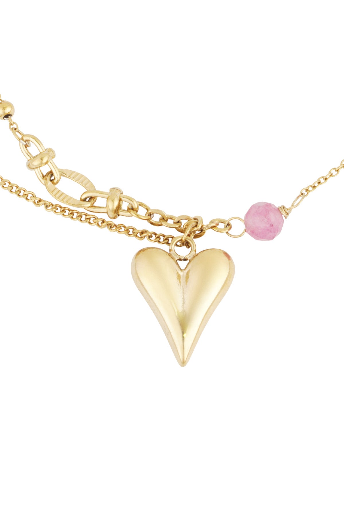 Detailed view of the gold heart charm pendant and pink bead on the golden charm bracelet