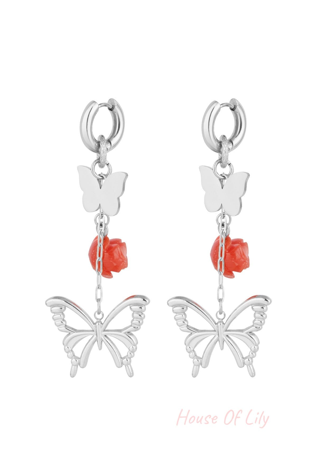 Silver butterfly and rose drop earrings close-up on white background