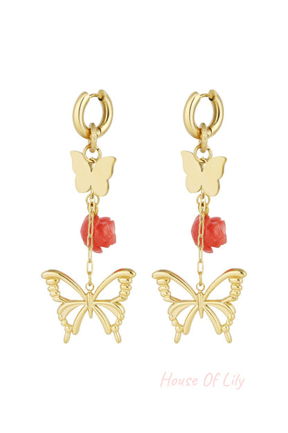 Pair of gold butterfly and rose drop earrings with chain links on a white background