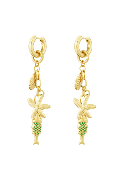 Pair of gold-tone drop earrings featuring starfish, seashell and green enamel fish charms on white background