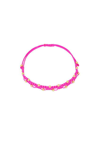 Close-up of bright pink braided bead bracelet on white background