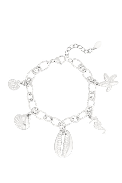 Silver-tone charm bracelet with large textured links and sea-themed charms including starfish, seahorse, shell, and cowrie shell on a white background.