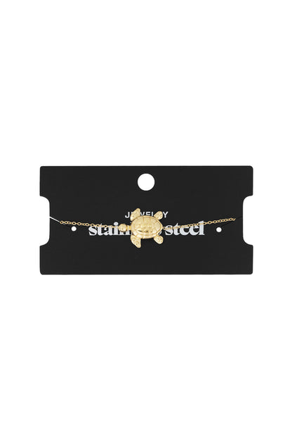 Gold turtle charm bracelet displayed on black card packaging labelled 'stainless steel jewellery'