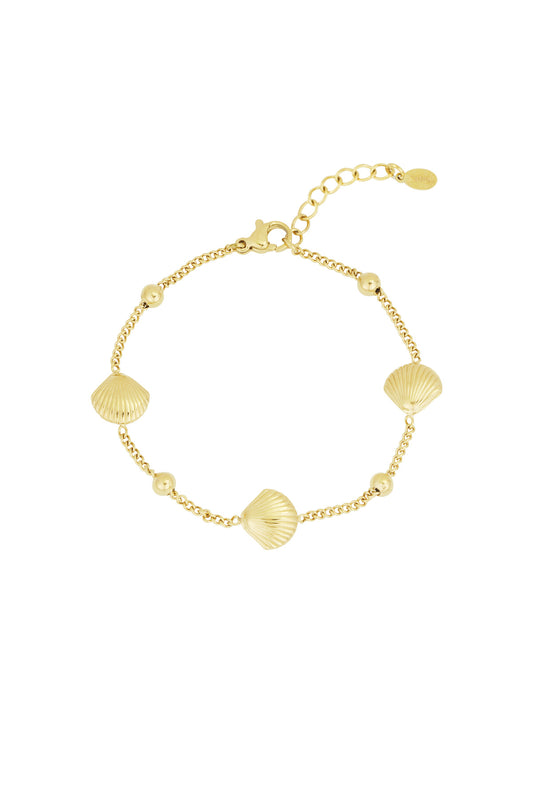 Gold seashell charm bracelet with round beads and adjustable chain laid flat on white background