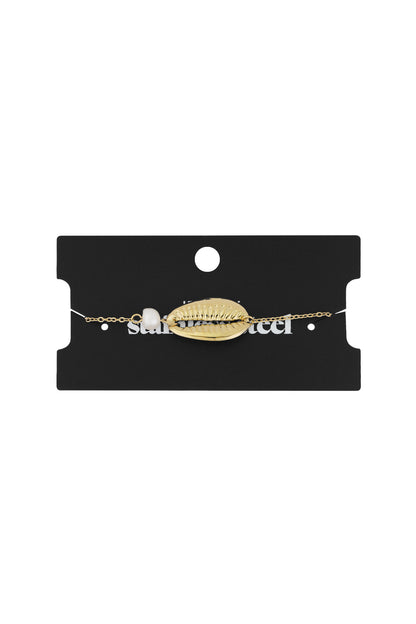 Gold shell charm bracelet displayed on black jewellery packaging card
