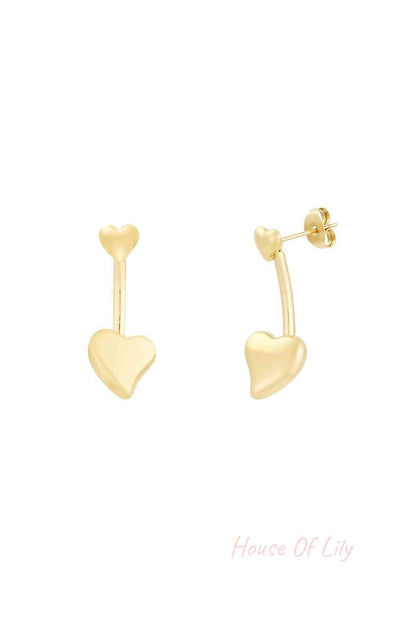 Close-up of gold double heart drop earrings with small heart stud and larger heart drop