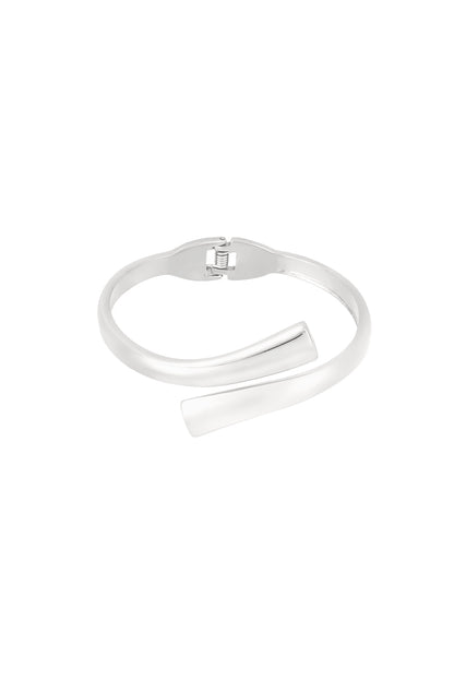 Silver spiral-shaped cuff bracelet with hinged clasp on white background