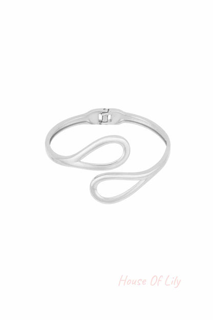 Silver-toned cuff bracelet with open loop design on white background