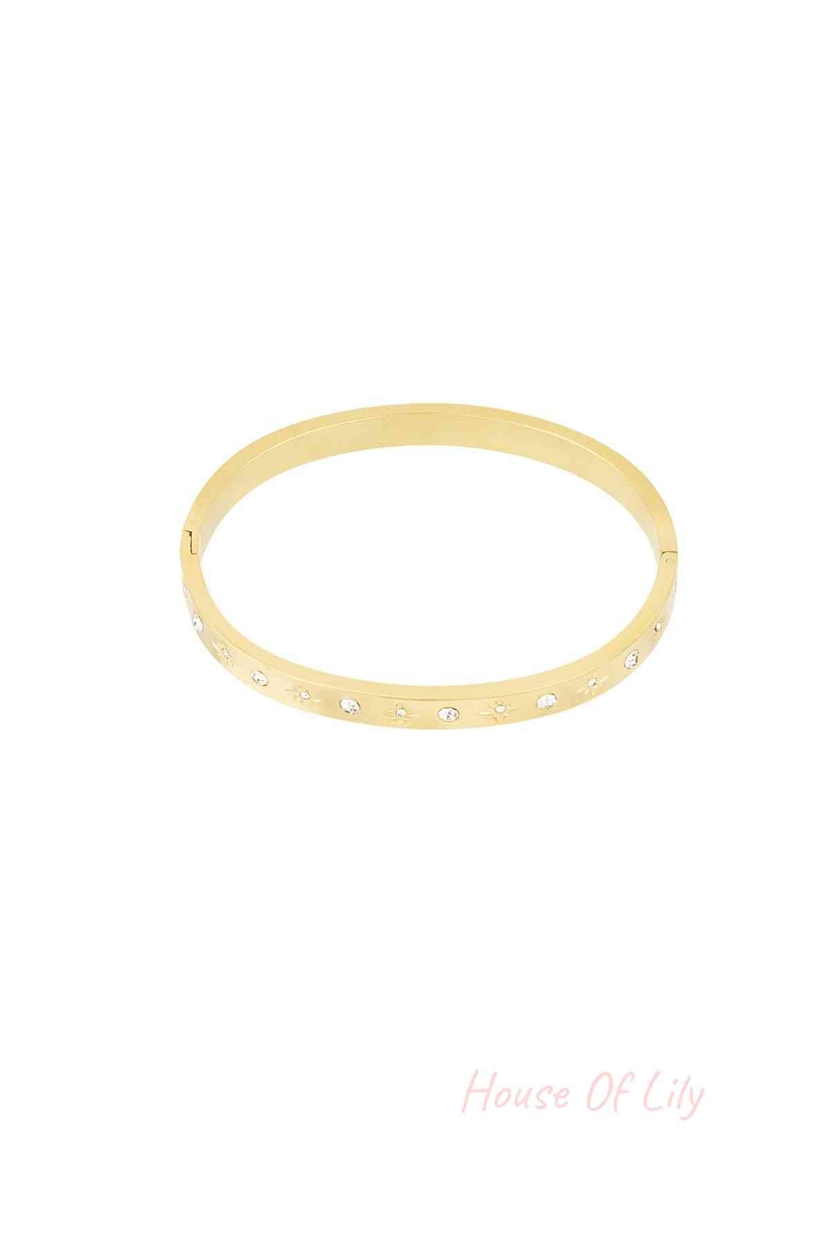 Gold-tone bangle bracelet with star-shaped engravings and crystal accents on a white background