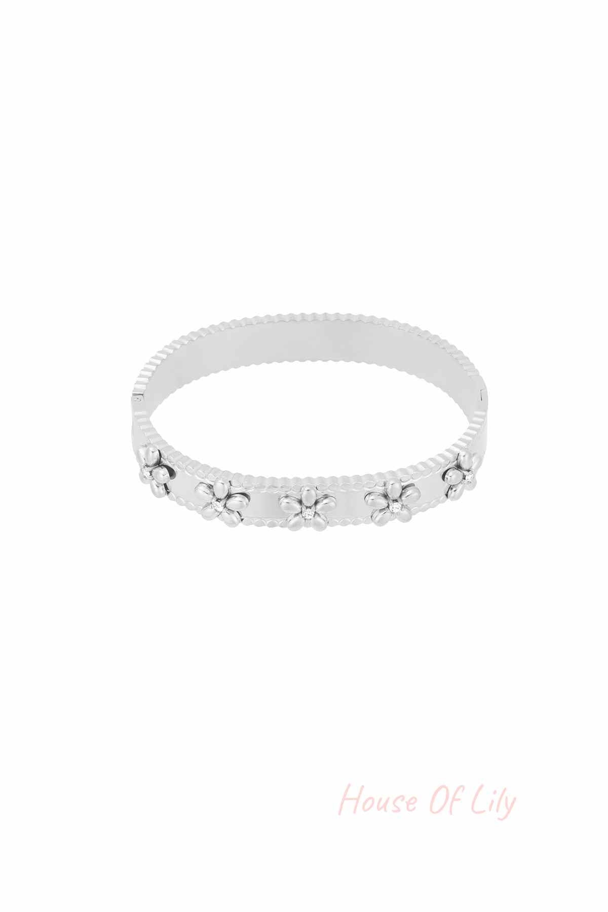 Silver floral bangle bracelet with rhinestone accents on white background