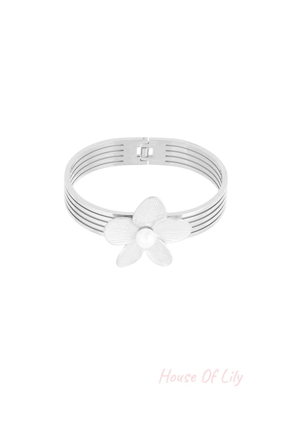 Silver-tone multi-strand bangle bracelet with textured flower and pearl centre displayed on white background
