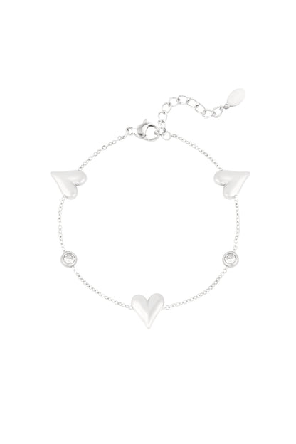 Silver tone stainless steel bracelet featuring heart charms and crystal accents shown on white background