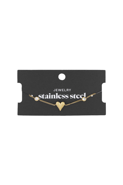 Gold tone heart charm bracelet displayed on black card labelled 'stainless steel jewelry'