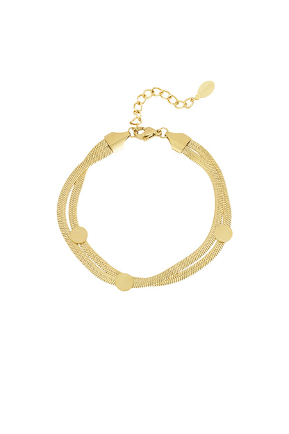 Close-up of a gold-tone stainless steel flat chain bracelet with three round dot accents and adjustable clasp
