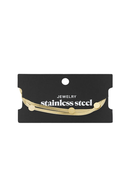 Gold-tone stainless steel flat chain bracelet with dot accents displayed on black card labelled stainless steel jewellery