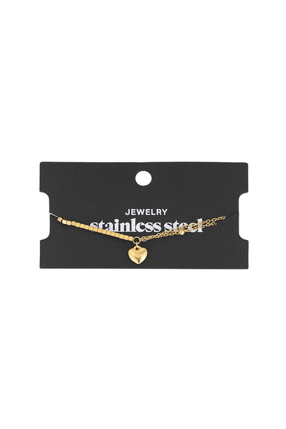 Gold heart charm bracelet displayed on black stainless steel jewellery card