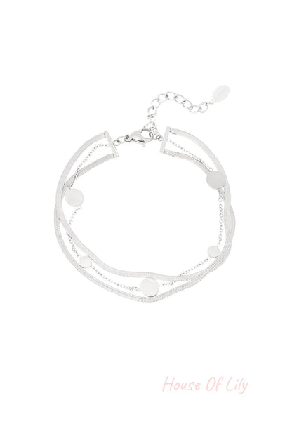 Silver-tone stainless steel bracelet featuring layered chains and round coin charms laid flat on white background