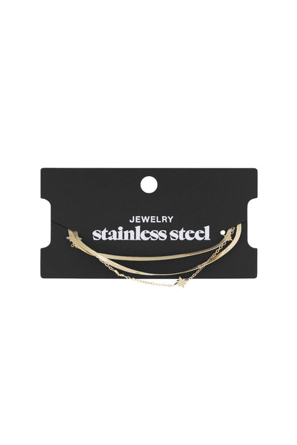 Black packaging card with ‘stainless steel jewellery’ text holding the gold layered star charm bracelet