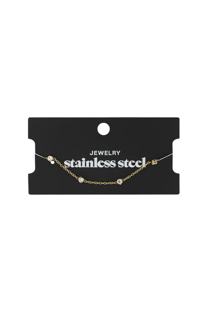 Gold crystal chain bracelet displayed attached to a black card labelled 'stainless steel jewellery'