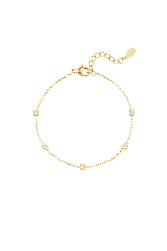 Gold delicate chain bracelet with five sparkling crystal stones evenly spaced on white background