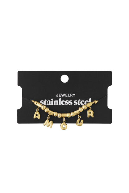 Gold stainless steel AMOUR charm bracelet displayed on black jewellery card with white lettering
