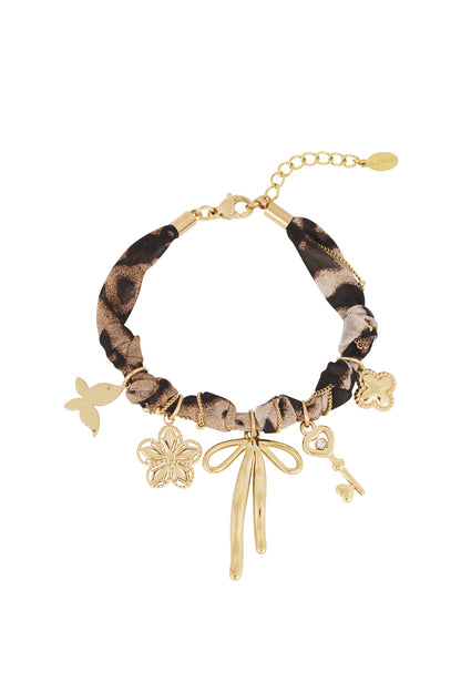 Leopard print charm bracelet with gold-tone bow, key, flower, butterfly, and clover charms on white background