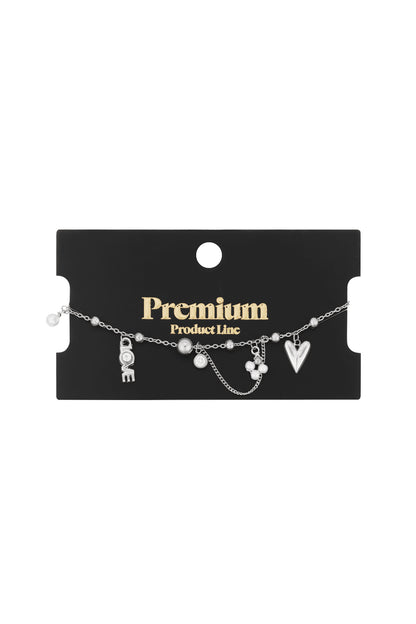 Black card packaging showing silver-tone charm bracelet with heart, LOVE lettering charm with crystal and pearl details