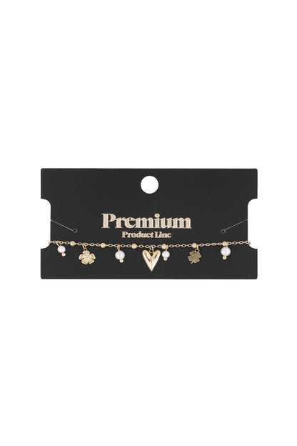 Gold charm bracelet displayed on black premium product packaging showcasing its shimmering design and charm details