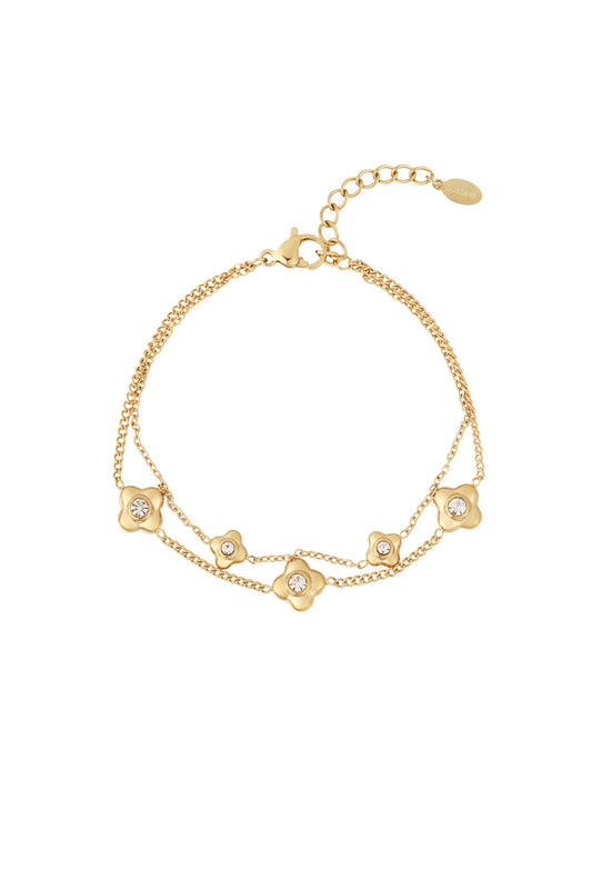 Gold double chain bracelet featuring five small flower charms each with a crystal center on white background