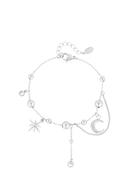 Silver celestial charm bracelet with moon, star, and bead charms on white background